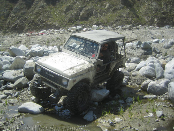 White 1987 Suzuki Samurai navigating rocky terrain