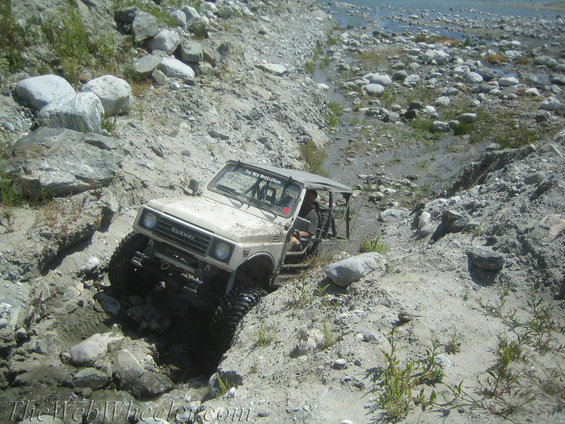 Suzuki Samurai navigating a rocky, dry creek bed