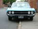 1970 Ford Ranchero - A blue 1970 Ford Ranchero is seen from the front, parked on a street with a curb.