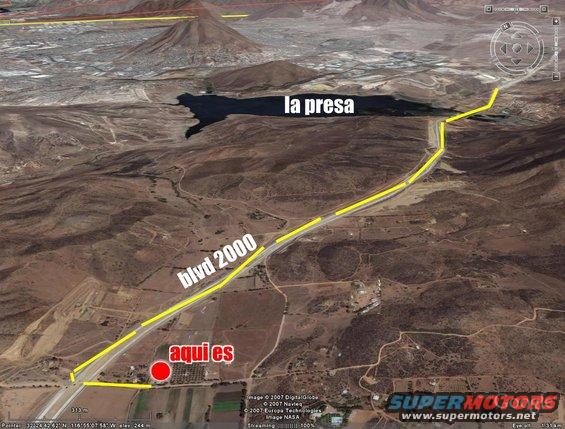 Aerial view of a highway labeled 'blvd 2000' with a body of water labeled 'la presa' and a red marker labeled 'aqui es'