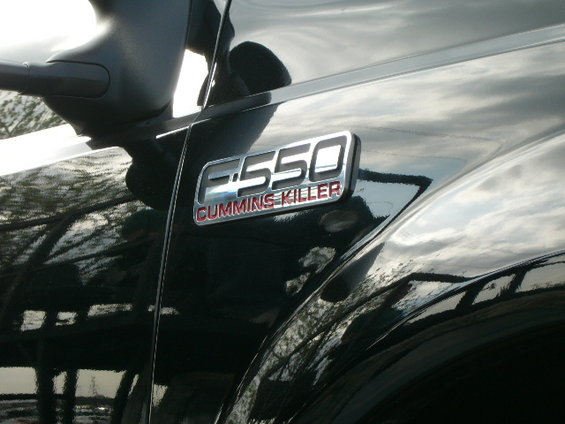 Close-up of F-550 badge with "CUMMINS KILLER" text on a black truck