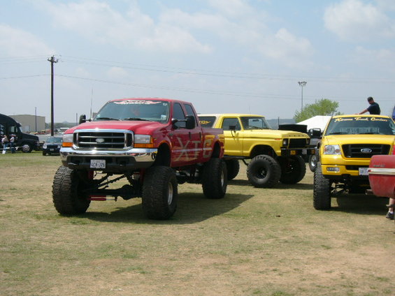 Red Ford F-250 truck with lifted suspension and large tires, front view
