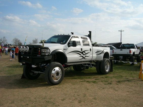 White lifted dually pickup truck with tribal graphics and large front bumper