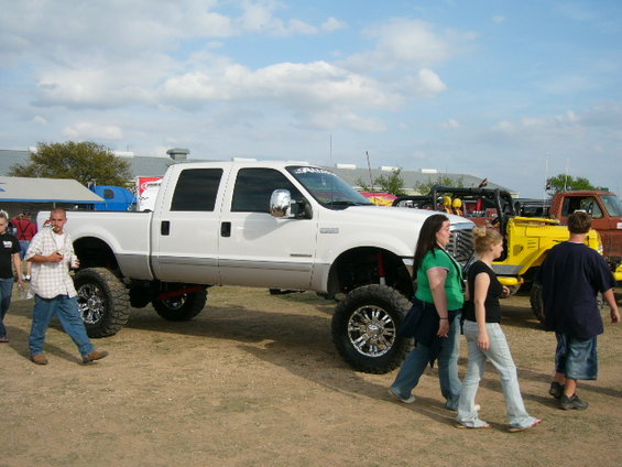 Lifted white pickup truck with chrome wheels and tinted windows