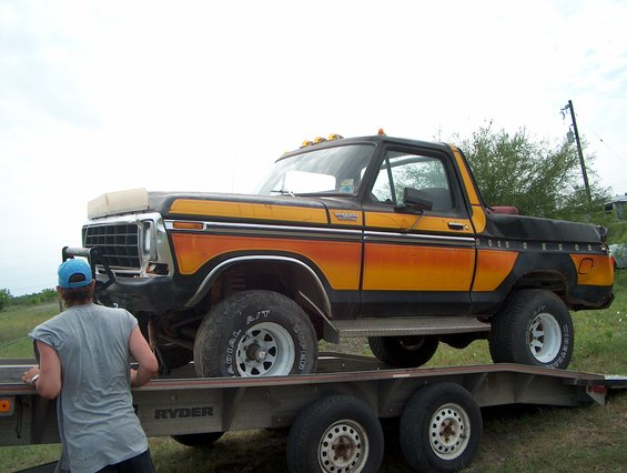1979 Ford Bronco on a flatbed trailer, orange and black paint scheme