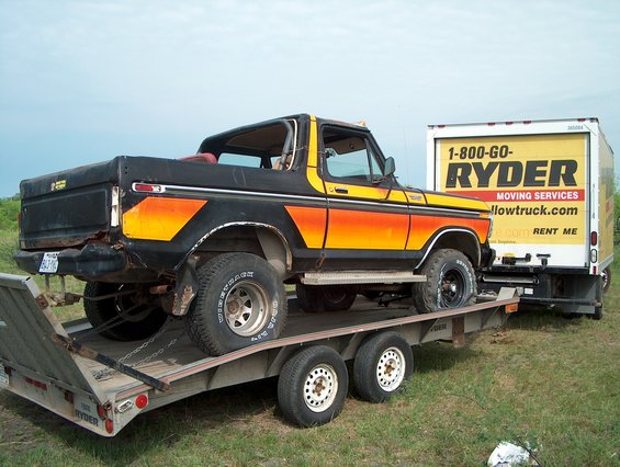 Bronco on trailer being towed by a Ryder truck