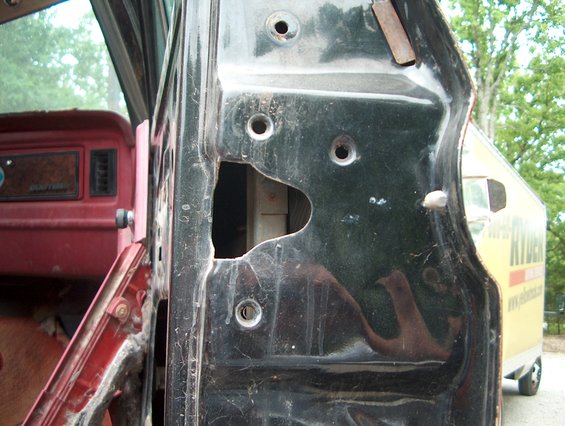 1979 Ford Bronco door jamb with interior visible, Ryder truck in background