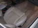 1995 Ford Taurus - The interior of a car features a light-colored leather passenger seat and beige carpeting on the floor.