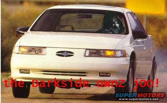 White 1992 Ford Taurus, front view, with red text overlay "the Darkside ownz joo!" and Supermotors logo