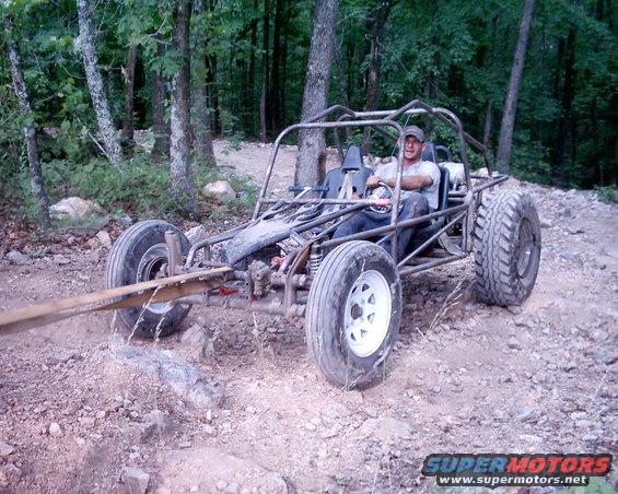 Off-road buggy with roll cage and large tires on a dirt trail