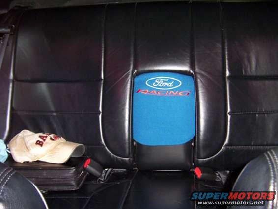 Black leather car seats with a blue Ford Racing headrest and a baseball cap on the seat