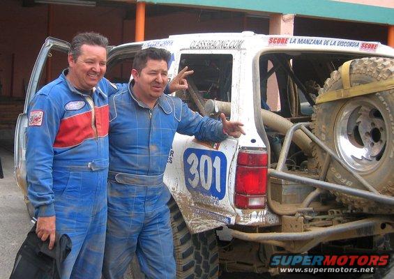 1992 Ford Explorer modified for off-road racing, with number 301 on the side, and two men in racing suits