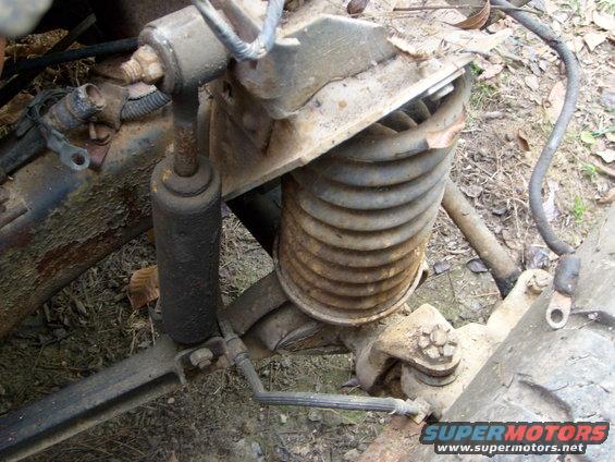 Close-up of a rusty engine swap part with a SuperMotors logo