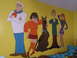 1988 Ford Bronco - A mural of Scooby-Doo, Shaggy, Daphne, Velma, and Fred adorns a bright yellow wall.