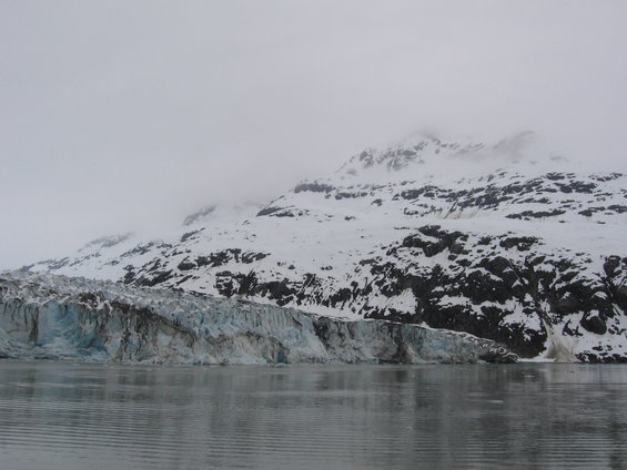 Glacier and snow-covered mountains under a cloudy sky