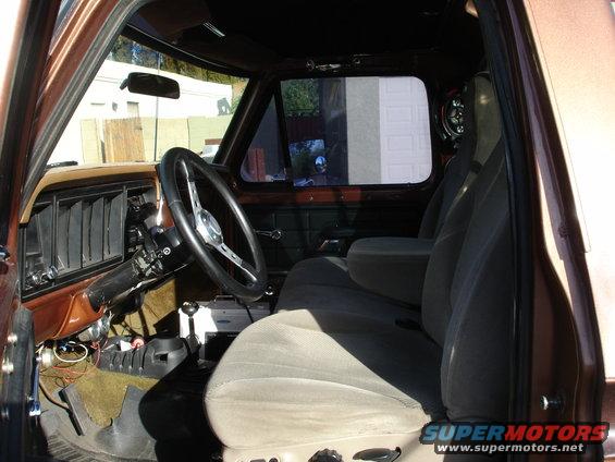 Interior of a brown truck, showing the dashboard, steering wheel, and seats
