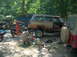 1996 Ford F-250 - A Jeep Grand Wagoneer is undergoing repairs outdoors, with parts and tools scattered around.