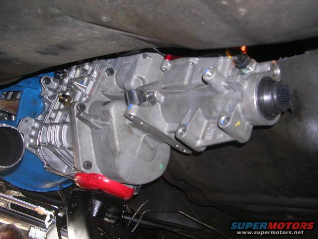 Close-up of a vehicle's transmission and exhaust pipe, viewed from underneath