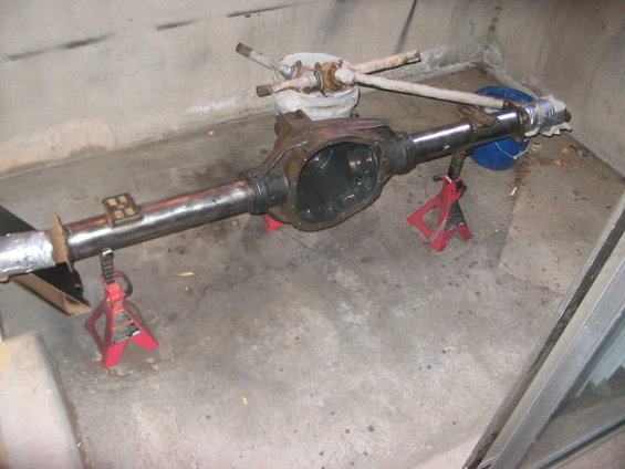 Rear axle assembly on red jack stands, with some parts attached