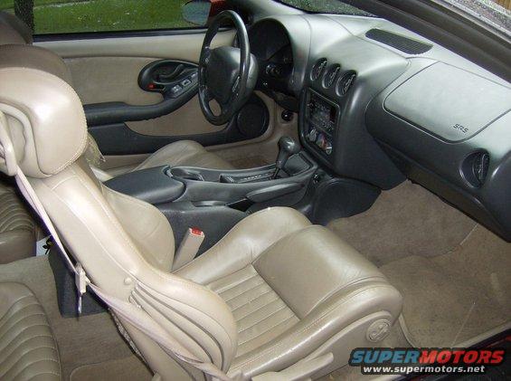 Tan leather interior of a 1996 Pontiac Trans Am, showing seats, dashboard, and center console