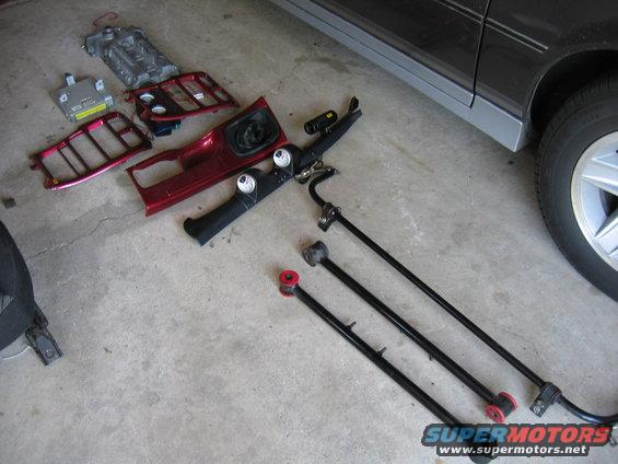 Red interior trim piece and suspension parts on concrete