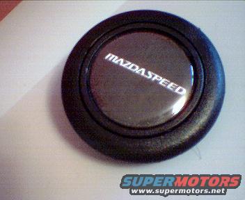 Mazdaspeed horn button with text on a white surface