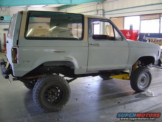 1986 Ford Bronco II body in primer, on a yellow jack, in a workshop