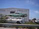 1989 Ford Bronco - Junkyard scene with a green 1957 Oldsmobile stacked on a white car under a building sign.