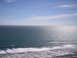 1989 Ford Bronco - Ocean waves meet the shore under a vast expanse of sky.