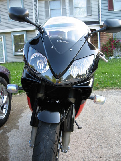 2004 Honda CBR600F front view. Black fairing with dual headlights and 'HONDA' logo