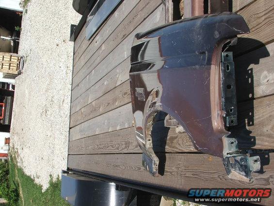 Fender off a truck or SUV, brown color, on a wooden trailer