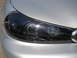 1992 Ford Taurus - The driver's side headlight assembly of a silver car is shown in detail, a black housing and clear lens.