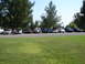 1992 Ford Taurus - A group of cars are parked in a lot on a sunny day, with people milling about.