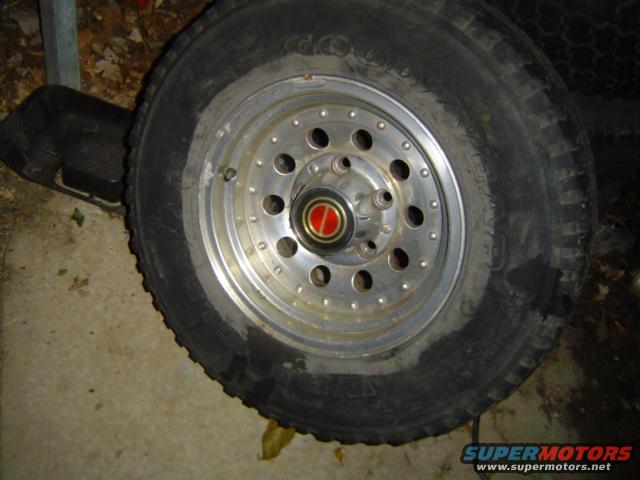Close-up of a vehicle wheel with a red and silver center cap. Tire has 'GOOD YEAR' visible