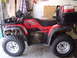 1999 Honda RANCHER - Side view of a red 2006 Honda Foreman ES ATV with added accessories.