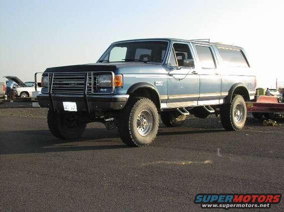 Blue SUV with brush guard and side pipes, 3/4 front view
