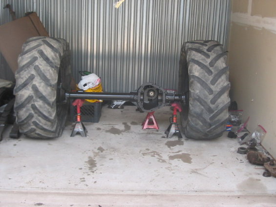 Rear axle assembly on jack stands with two large tractor tires
