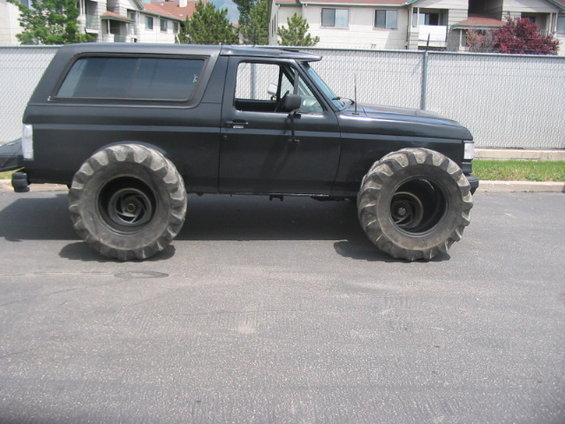 Black SUV with oversized tractor tires, side view