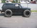 1991 Ford Bronco - This modified SUV features massive tractor tires, giving it a unique and imposing stance.
