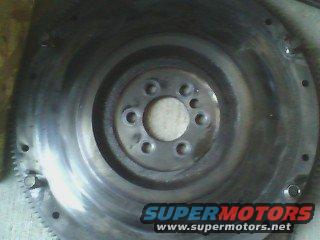 Metal flywheel with bolt holes and gear teeth, SuperMotors.net logo visible