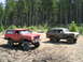 1979 Ford Bronco - Two off-road ready Ford Broncos are covered in mud after a day of driving through the forest.