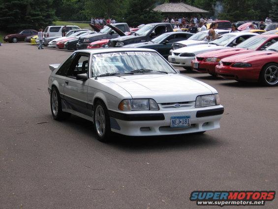 White Saleen Mustang with a rear spoiler and a 'SALEEN' banner on the windshield