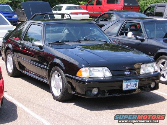 Black 1989 Ford Mustang coupe parked outside with other cars