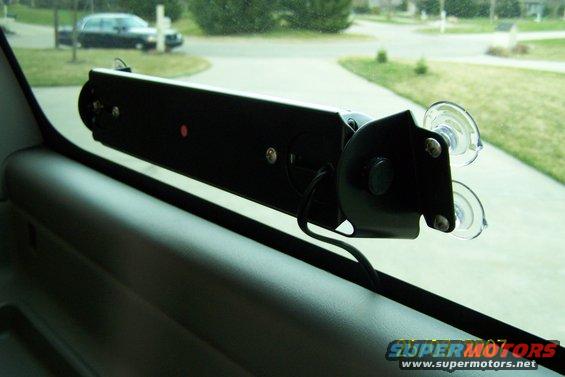 Interior light bar mounted with suction cups on a car window, with another car visible outside