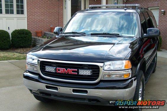 Black GMC Yukon SUV front view with light bar on roof