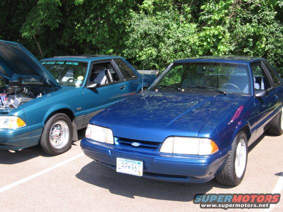 Blue 1989 Ford Mustang front view with a teal Mustang behind it