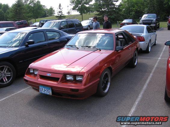 Red 1989 Ford Mustang coupe with a license plate reading GYJ-357