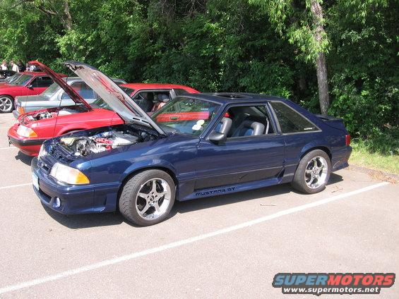 Dark blue 1989 Ford Mustang GT, hood open, parked in lot with other cars