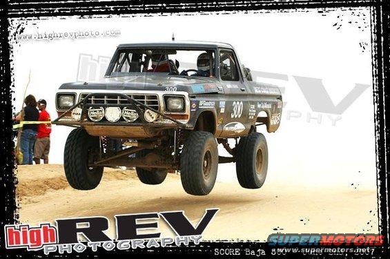 Off-road race truck mid-air jump, number 300 on door, Baja race markings