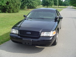 Black 2001 Ford Crown Victoria Police Interceptor, front 3/4 view, parked on asphalt driveway